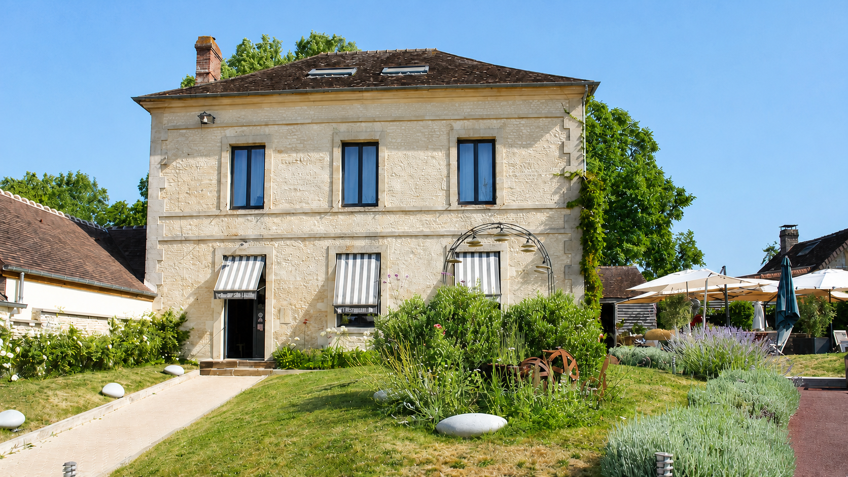 Maison, jardin fleuri et terrasse du restaurant à Goulet, Monts-sur-Orne